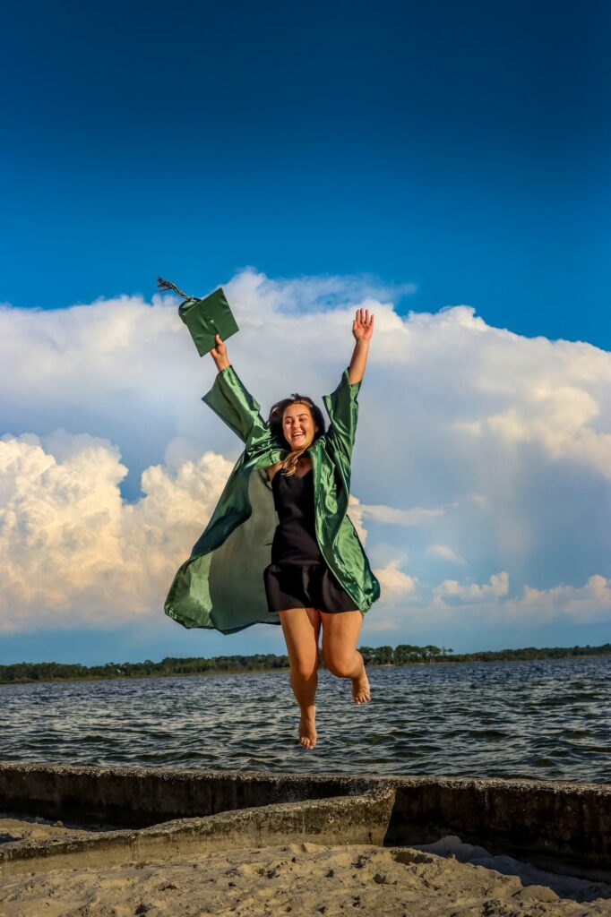 A young lady jumping for joy for graduation day. Congratulations Class of 2022!